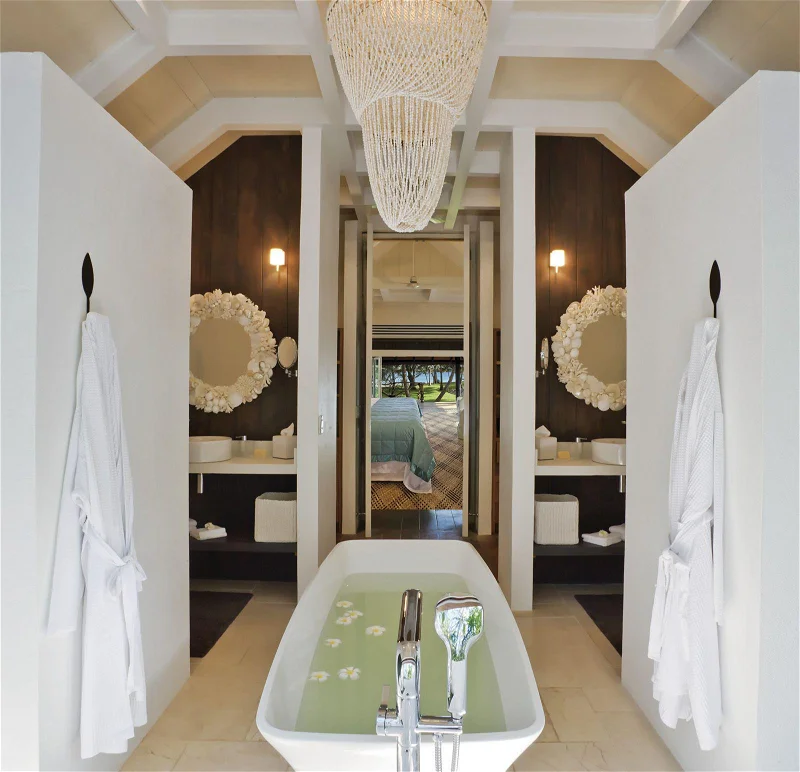 Imagem de banheira cheia de água e dois espelhos pendurados na parede.